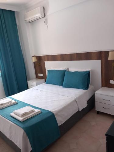 a bedroom with a large bed with blue pillows at Bena pansiyon in Fethiye