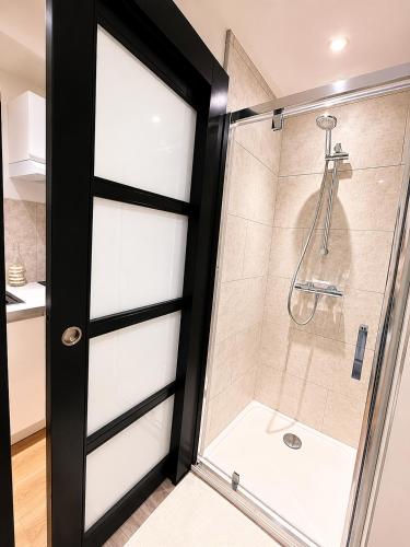 a bathroom with a shower with a glass door at L'Instant Saint-Epvre Charm & Old Town in Nancy