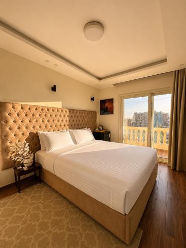 a bedroom with a large bed and a large window at Hadayek Al-Ahram Guest House - حدائق الاهرام جيست هاوس in Giza