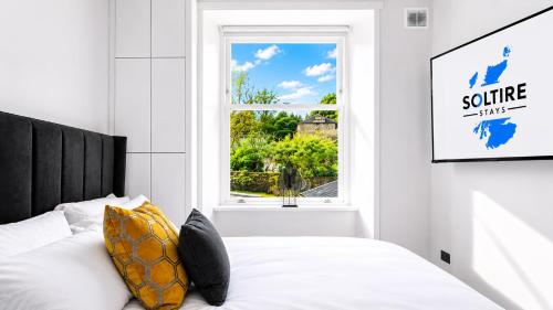 a bedroom with a bed and a window at The Fountain View Apartment in Rothesay