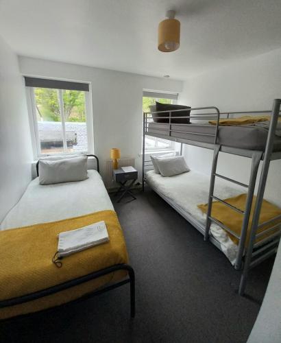 a bedroom with two bunk beds and a window at Hartfield House Hostel in Applecross
