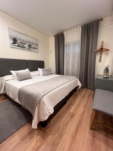 a bedroom with a large bed and a wooden floor at Time Holiday´s House in Olhão