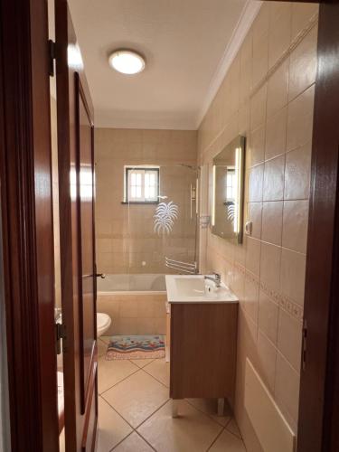 a bathroom with a sink and a bath tub at Monte Gordo T1 - Estrela do Mar in Monte Gordo