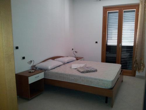 マルティンシクーロにあるIl Ventaglio Apartmentのベッドルーム1室(ベッド1台、ナイトスタンド、窓付)