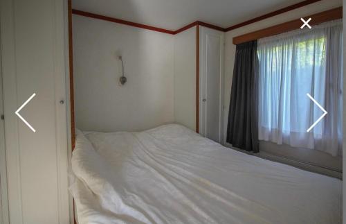 a bedroom with a bed and a window with arrows at Champagnehuisje in Voorthuizen