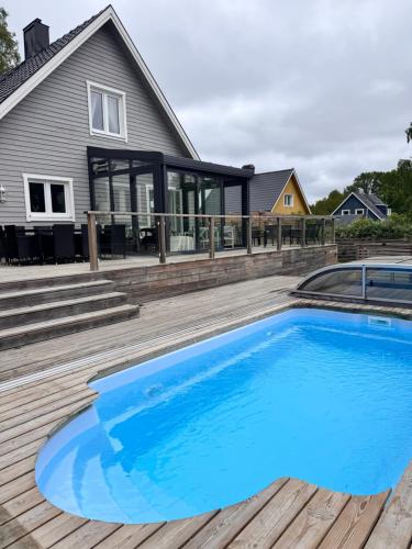 a swimming pool on a deck with a house at The Cheerful Villa In Perstorp in Perstorp