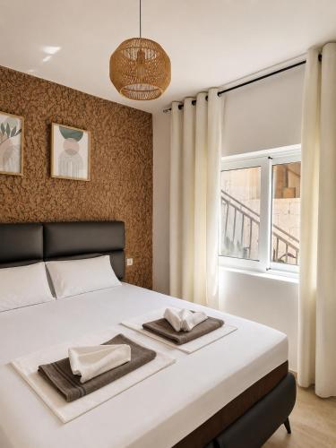 a bedroom with a white bed with a large window at Monte Liza Apartments in Dobra Voda