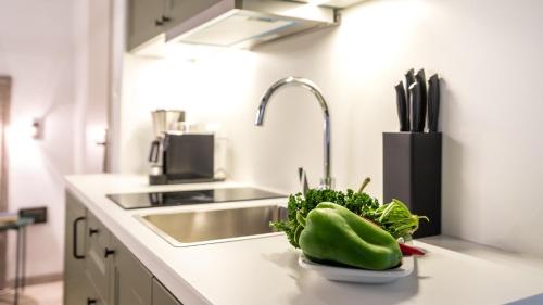a kitchen with a sink and a bowl of vegetables on a counter at Beach Suite Nina in Rab