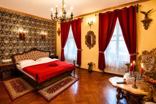 a bedroom with a bed and red curtains and a table at History Apartments Cetății in Sibiu
