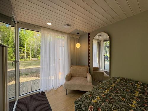 a bedroom with a bed and a chair and a window at MetsaMaja in Hiiumaa
