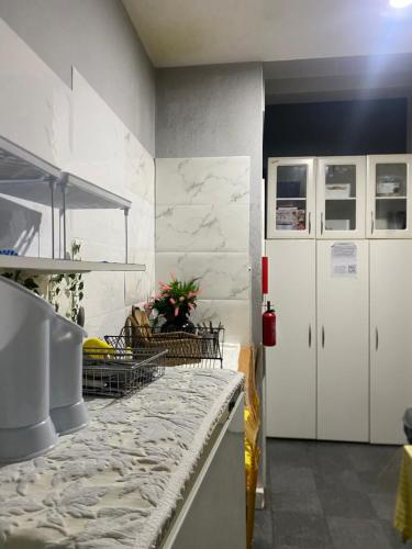 a kitchen with white cabinets and a marble counter top at Hostel da Maria - Porto in Vila Nova de Gaia