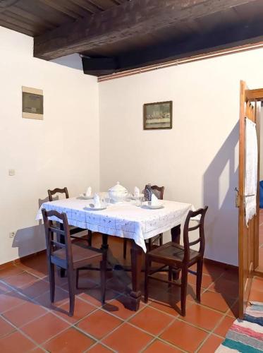 a dining room table with chairs and a white tablecloth at Rusticca M- slavonska kuća in Rokovci