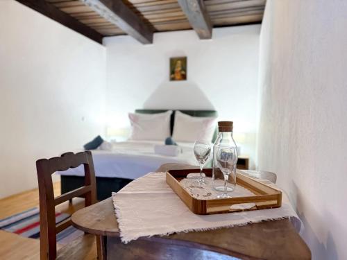 a table with two wine glasses on it with a bed at Rusticca M- slavonska kuća in Rokovci