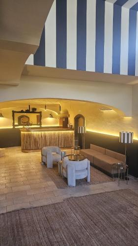 a living room with two couches and a table at Capomulini Boutique Hotel in Capo Mulini