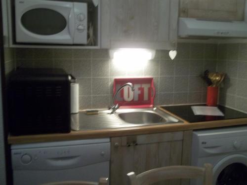 a kitchen counter with a sink and a microwave at Les Gloriettes in Luz-Saint-Sauveur