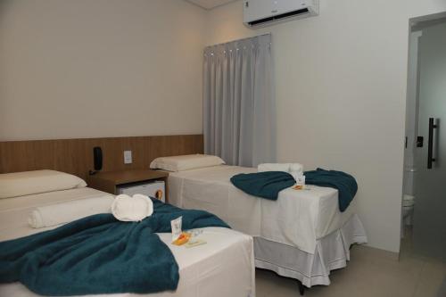 ein Krankenzimmer mit drei Betten und blauen Decken in der Unterkunft Mairí Hotel in Itaituba