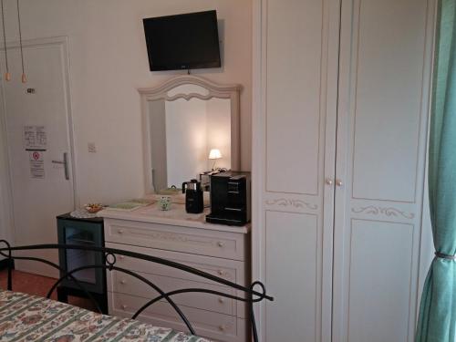 Le Midi Versilia في ليدو دي كامايوري: غرفة نوم مع خزانة مع ميكروويف ومرآة