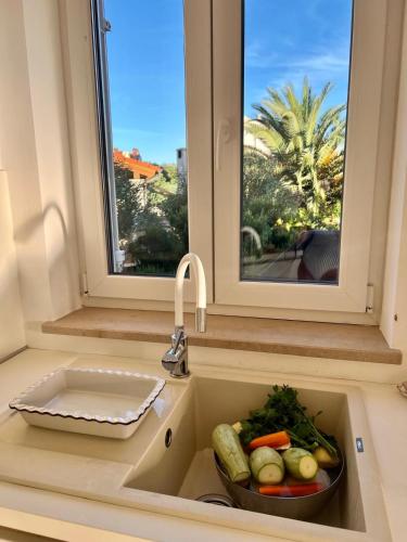 a kitchen sink with a bowl of vegetables in it at Four bedroom Beach House Amaya Medulin in Medulin