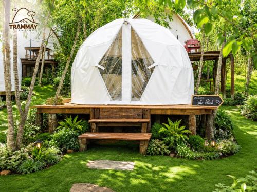 a tent in a garden with a bench at Trạm Mây Glamping in Da Lat