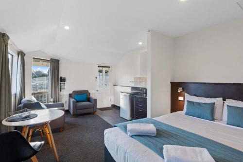 a bedroom with a large bed and a living room at Ashford Motor Lodge in Christchurch