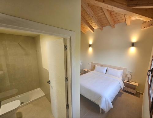 a bedroom with a white bed and a shower at Hostal JP y Estudios in Sangüesa