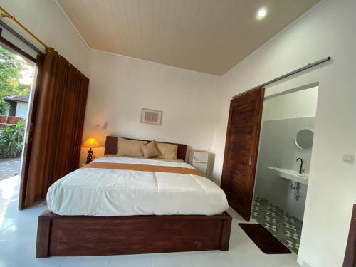 a bedroom with a large bed and a bathroom at Pondok tulamben in Karangasem