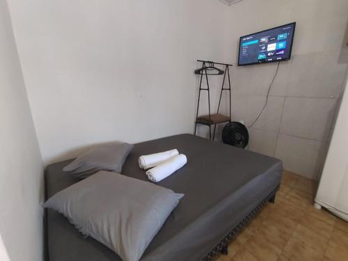 a bedroom with a bed with two pillows and a tv at Casa completa - Ótimo Custo-benefício in Itajaí