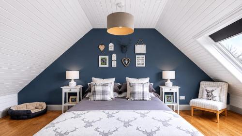 a bedroom with a bed and a blue wall at The Stay at Straad in Island of Bute