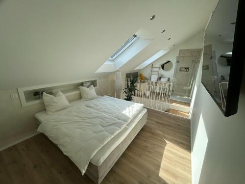 a bedroom with a large white bed in a room at Chambre haute in Eupen