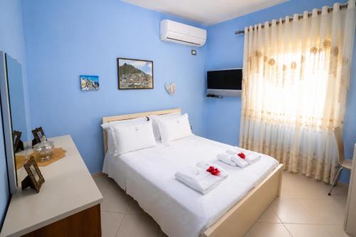 a blue bedroom with a bed with towels on it at Villa Nano in Berat
