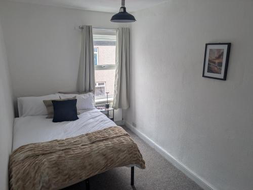a small bedroom with a bed with a window at Grange Retreat in Pontnewydd