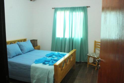 a bedroom with a bed with blue sheets and a window at Lo de Chimila in San Javier