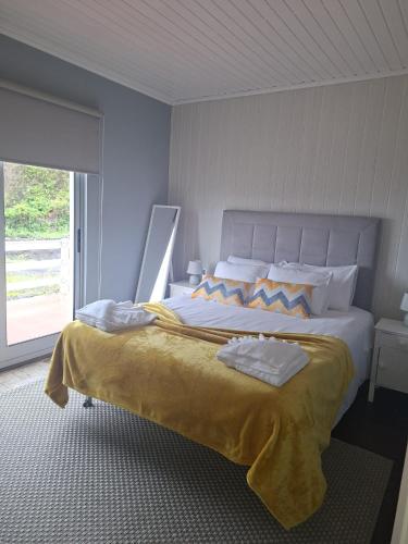 a bedroom with a large bed with a large window at Chez Tronqueira 43 in Faja Grande