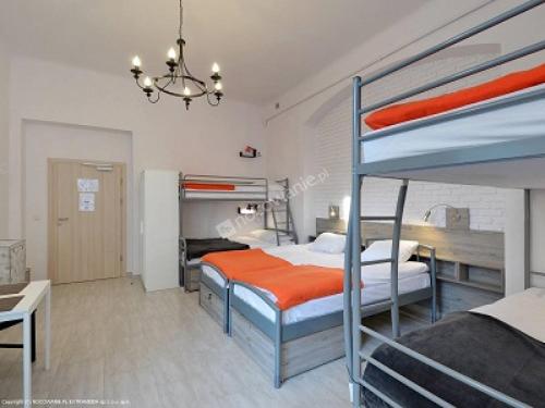 a bedroom with two bunk beds and a desk at Hostel Lwowska 11 in Warsaw