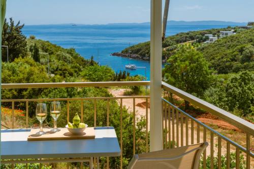 a table with wine glasses and a view of the ocean at Amorosa Nest - Adults Only by Eutopia in Syvota