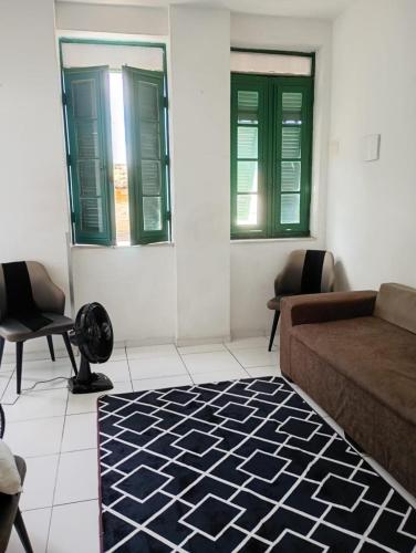 a living room with a couch and two windows at Boêmia carioca in Rio de Janeiro