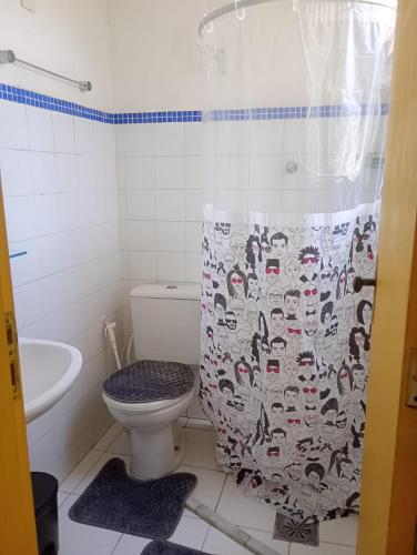a bathroom with a toilet and a shower curtain at Boêmia carioca in Rio de Janeiro