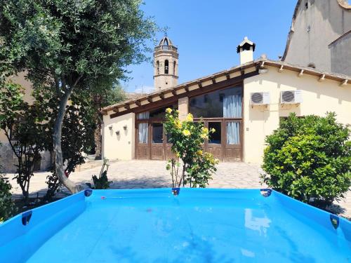a villa with a swimming pool in front of a house at Casa rural Cal Codina in Prats de Rey
