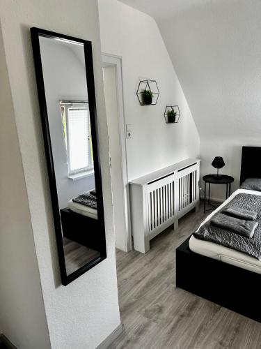 a room with a mirror and a bed and a bed sidx sidx sidx at STAY - City W32 in Friedrichshafen