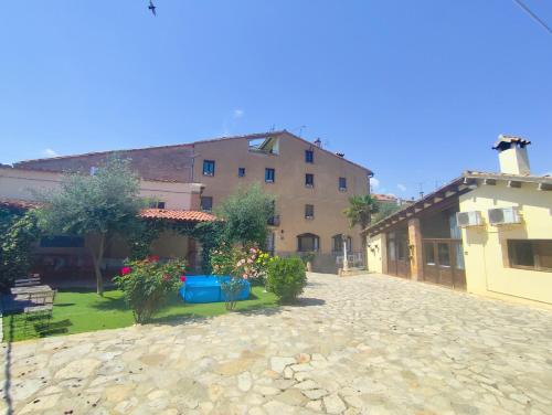 a courtyard of a house with a building in the background at Casa rural Cal Codina in Prats de Rey