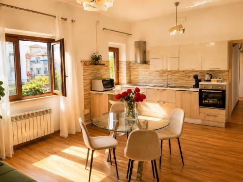 a kitchen with a glass table with chairs and a vase of flowers at Casa Annalisa in Scauri