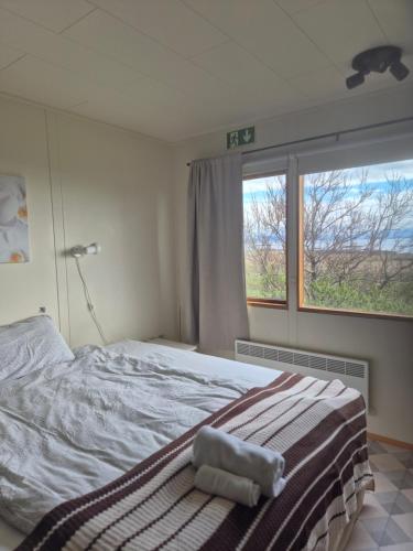 a bedroom with a large bed with a window at Miðjanes Reykhólahrepp in Reykhólar