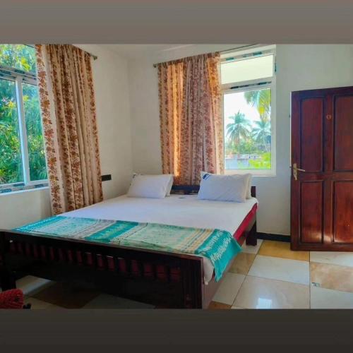 a bedroom with a large bed with a window at Tenstay Homes & Independent Villa in Virāmpattinam