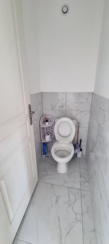 a bathroom with a white toilet in a room at La Grange in Champagne-de-Blanzac