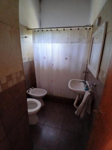 a bathroom with a toilet and a sink at Casa Las Tardes, Roldan in San Lorenzo
