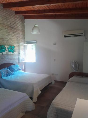 a bedroom with two beds and a window at Casa Las Tardes, Roldan in San Lorenzo