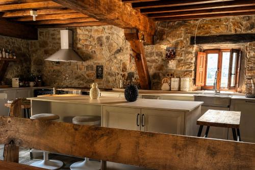a kitchen with a island in a room with stone walls at Laguna de Valfría in Fresneda