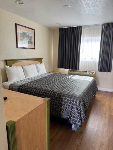 a bedroom with a bed with a black comforter at Castaway Motel in Orange