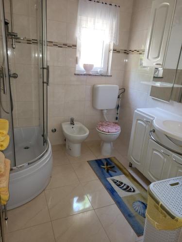 a bathroom with a toilet and a sink and a shower at Ferienwohnung mit Meerblick in Povile