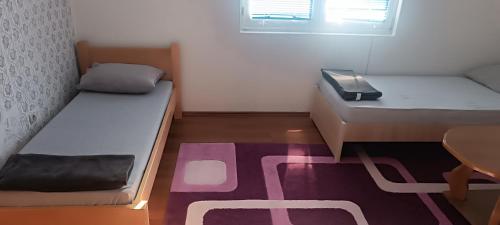 a small room with two beds and a table at Vila Ali in Krivoglavci